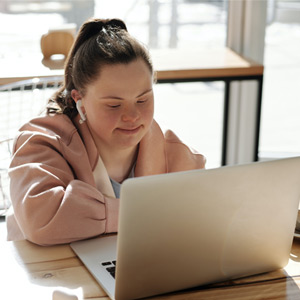 Femme atteinte du syndrome de Down assise devant son ordinateur